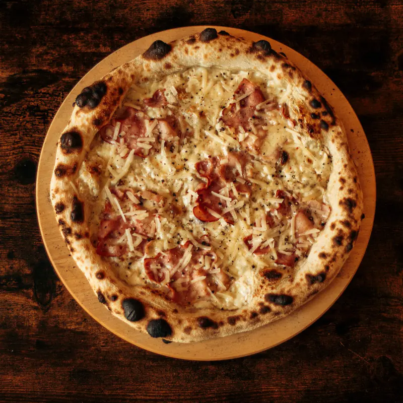 Pizza cu șuncă și mozzarella, pe un platou de lemn